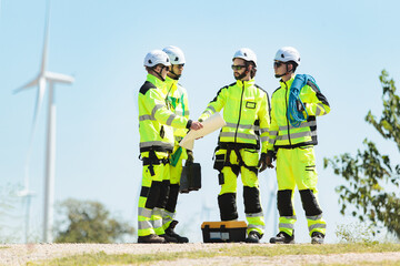 Fototapeta premium Team of engineers inspecting and planning maintenance at wind turbine power site. They discuss and collaborate on installation, renewable energy, alternative power, and sustainability for clean future