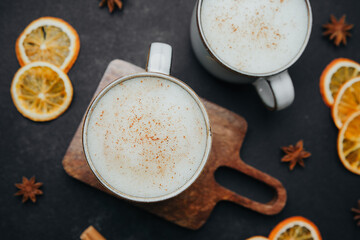 Warm spiced beverage in ceramic mugs with dried orange slices and star anise