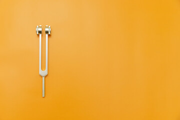 tuning fork on Orange Background, Space for Text, Space for Logo, medical instrument, medical...