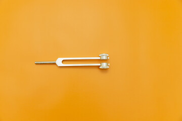 tuning fork on Orange Background, Space for Text, Space for Logo, medical instrument, medical...
