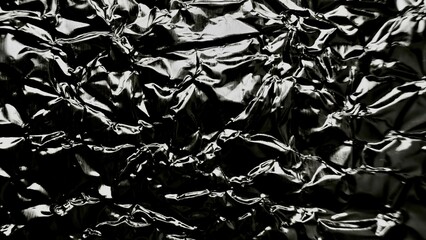 crumpled metallic black foil texture with reflective glossy folds perfect for modern background or abstract design surface