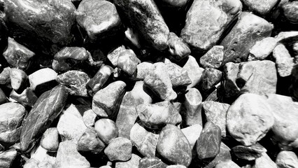 glossy monochrome river stones with wet reflections and sharp contrasts ideal for abstract background or natural texture design
