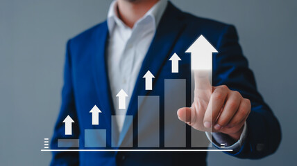 Man in blue suit touching glowing upward arrow graph on screen business finance