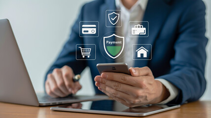 Man using smartphone with digital payment icons and laptop on desk image