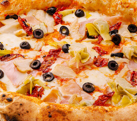 Gourmet pizza topped with artichokes, olives, and sun-dried tomatoes