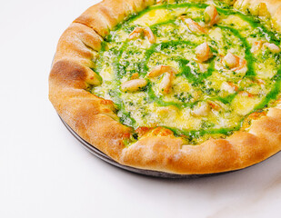 Unique green pesto pizza topped with shrimp served on white table
