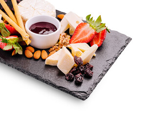 Delicious cheese platter with fruits and nuts arranged on a slate board