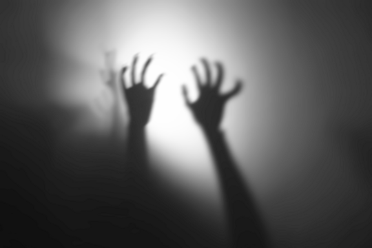 silhouette of hands in spotlight,Shadow overlay effect for halloween background with Terrifying scary hands with long nails,Creepy monster claw,silhouette of hands,zombie hand rising out of a graveyar