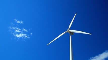 Fototapeta premium White wind turbine against a vivid blue sky with scattered clouds