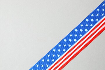 Top view of ribbon with USA flag on gray background. Top view, space for text