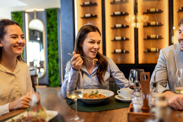 Colleagues Enjoying Lunch with Pasta and Wine at Restaurant