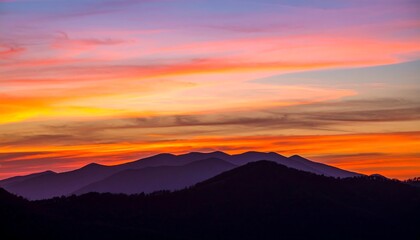 Vibrant sunset hues paint the sky above a silhouetted mountain range (3)
