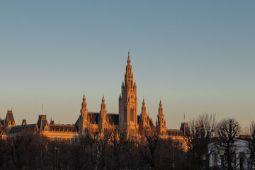 Naklejka premium Vienna, Austria 3-19-2025 The Vienna City Hall during golden hour is the town hall located at the rathausplatz in the centre of town. The Gothic Revival building was designed by Friedrich von Schmidt.