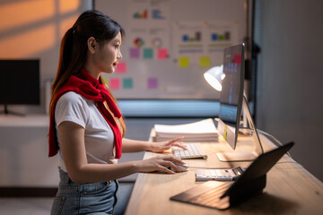 Young asian businesswoman working late using desktop computer in office