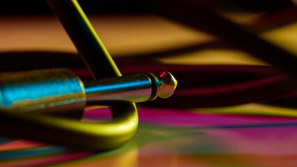 Audio jack connector on colorful background with neon glow. Concept of audio connection, retro...