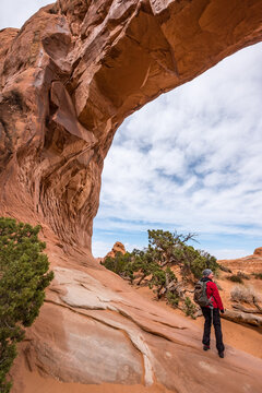 Wanderer unter gro&szlig;em Felsbogen im Arches Nationalpark