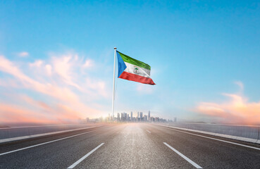 Equatorial Guinea national flag with mast waving with beautiful skyline. A view from highway....