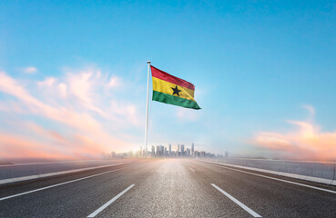 Ghana national flag with mast waving with beautiful skyline. A view from highway. Ghana flag for...
