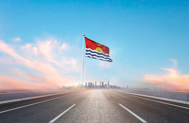Kiribati national flag with mast waving with beautiful skyline. A view from highway. Kiribati flag...