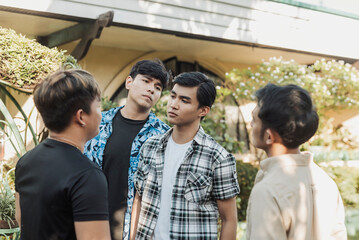 A quiet young Asian man is boxed in by three bullies who confront him aggressively, exerting social...