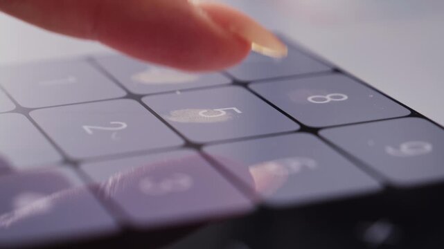 Footage of a person doing basic math on a smartphone calculator.