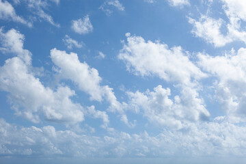 Fototapeta premium The deep blue sky provides a stunning backdrop for the crisp white, buoyant cumulus clouds.