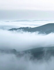 Fototapeta premium Mountains Partially Covered in White Fog with a Sky in Background during Daytime