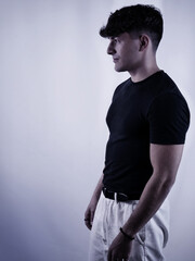 Man poses in stylish outfit under soft lighting