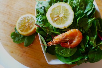 Mediterranean diet food with shrimps and spinach with lemon close macro detail