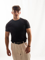Young man poses confidently in a studio against a neutral backdrop