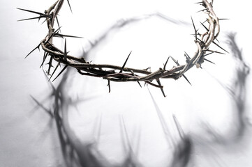 Crown of thorns casting a distinct shadow a white background, creating a symbolic easter image of...