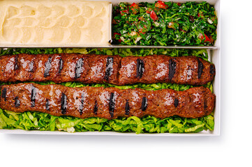 Delicious kebab platter with fresh herbs and creamy dip served in a restaurant