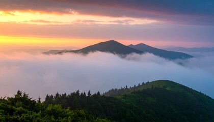 Obraz premium Sunrise over misty mountain range, showcasing vibrant colors and rolling hills
