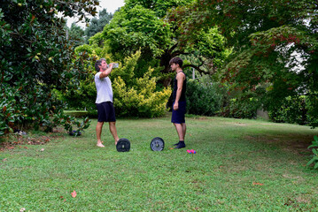 Outdoor workout session with two people in a garden