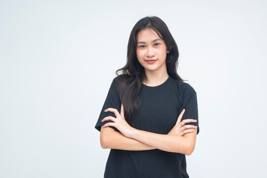 A strong young Asian woman posing with her arm folded, giving a fierce and smug smirk while locking eyes with the camera. Isolated on a white background.