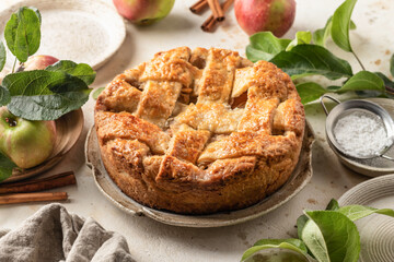 Homemade Apple Pie with fresh apples on textured background. Thanksgiving traditional dessert, autumn baking, recipe