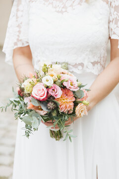 bride holding bouquet of pink roses