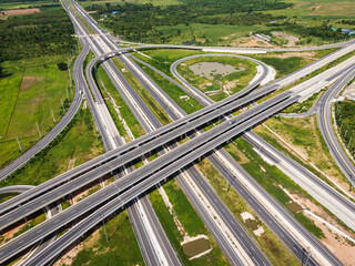 Drone shot a large highway interchange crossing over green farmlands in Thailand