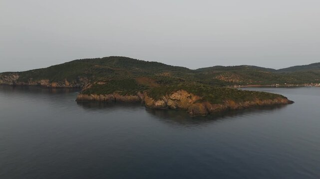 Aerial Drone Pan Out Shot Over Calm Aegean Sea From Paliouri, Kassandra, Halkidiki, Greece At Hazy Sunrise.