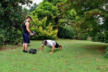 Outdoor workout session in the garden with weights and push-ups