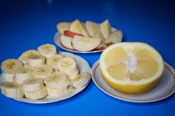 Sliced grapefruit and banana on a blue background.