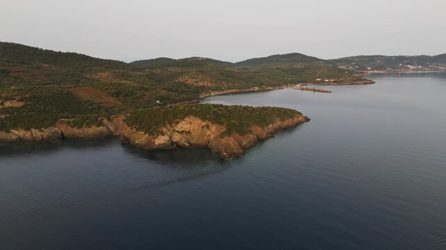 Aerial Drone Circle Shot Over Secluded Coast And Aegean Sea In Paliouri, Kassandra, Halkidiki, Greece At Sunrise On A Hazy Morning.
