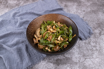 Stir-fried pork with chili peppers in a porcelain bowl