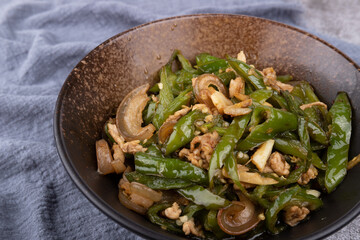 Stir-fried pork with chili peppers in a porcelain bowl