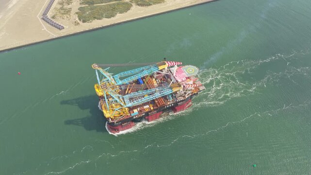 Daytime passage of pipelay crane ship across Rotterdam harbor, Netherlands