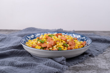 The sausage stir-fried with corn kernels on the plate