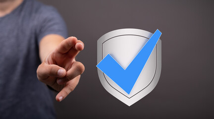 Hand reaching for a digital shield with a checkmark.  Cybersecurity, data protection, and online...
