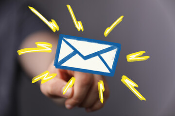 Close-up of a hand pointing at a bright email icon, symbolizing new message alert.