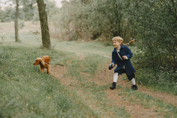 Little girl walks in autumn forest with a dog