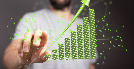 Stock photo of a hand interacting with a 3D green upward trending graph, symbolizing business...